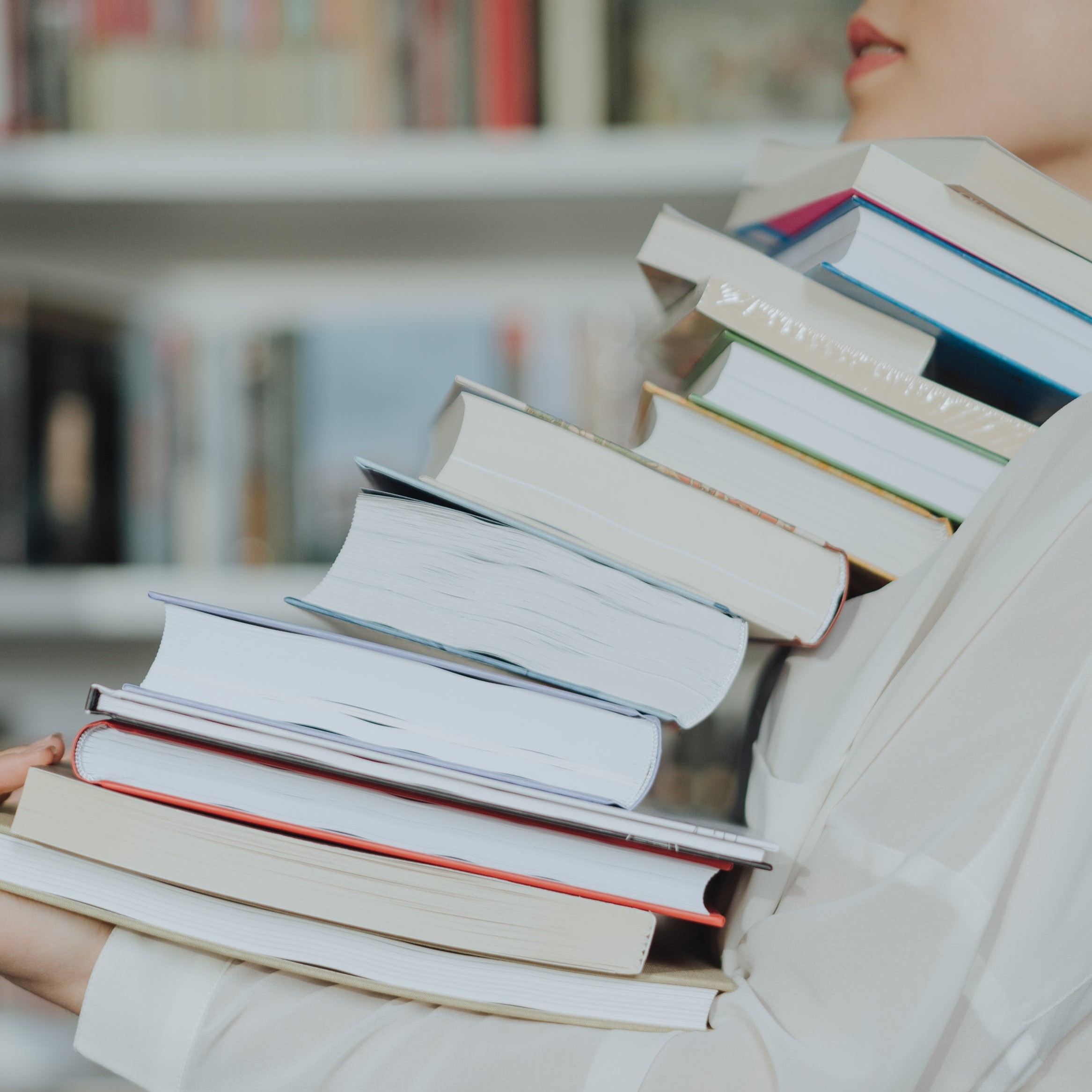 Woman carrying stack of books